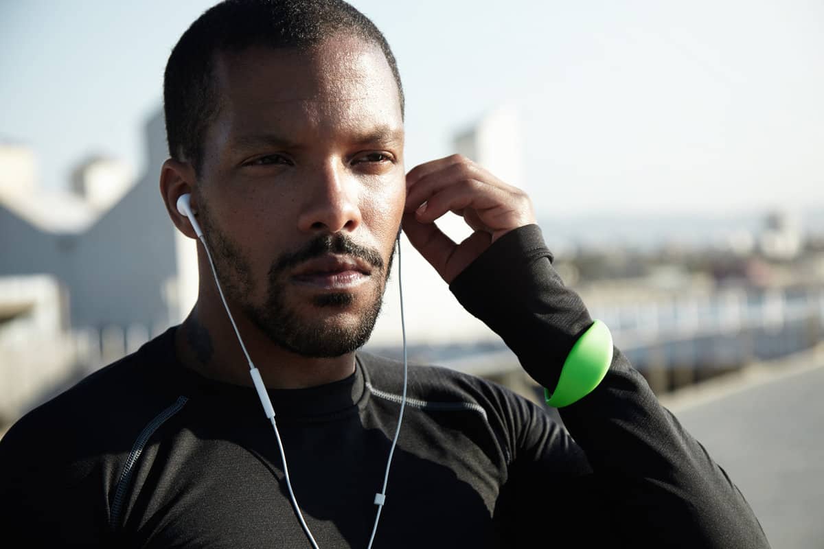 Close Up Shot Young Black Man With Beard Putting Headphone His Ear Determined Sportsman Is Ready Long Distance Run Workout Sunrise Athlete Wearing Sport Fitness Tracker